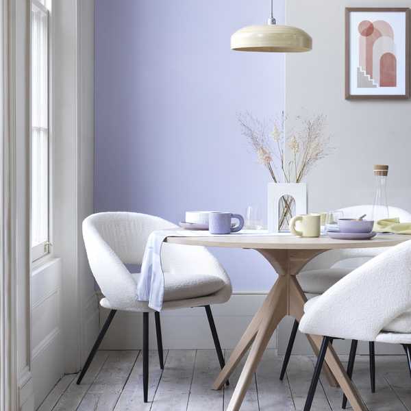 A white boucle dining chair paired with a wooden dining table.